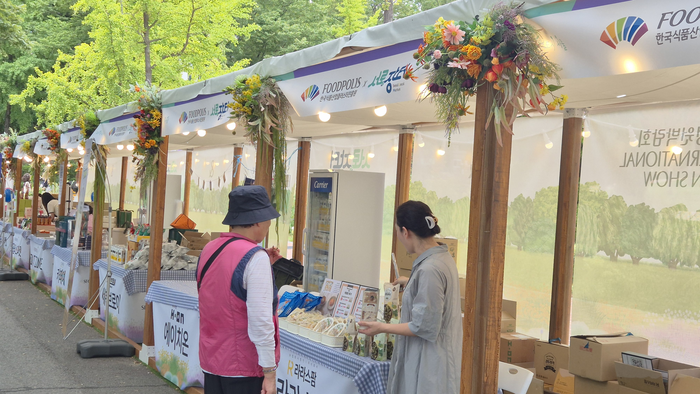 직거래장터 방문객이 국가식품클러스터 입주기업의 부스를 방문하여 상품을 살펴보고 있다. 사진|식품진흥원