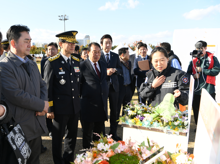 소방청 담당자가 주요 내빈(좌측에서부터 김종민 국회의원, 김승룡 소방청장 직무대행, 최민호 세종시장, 임채성 세종시의장)에게 ‘일상 그 사이’ 전시(순직자의 일상 속에 유가족의 추억이 담긴 물건 전시)를 설명하고 있다. 사진|소방청
