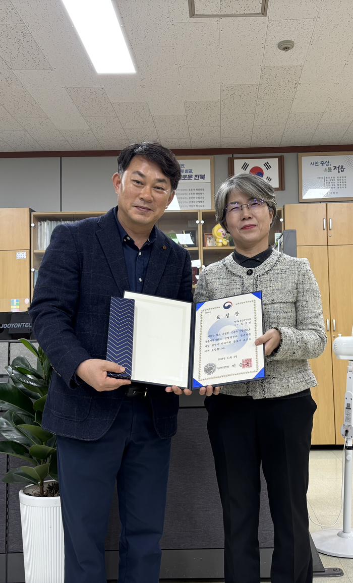 김상민 한국4-H정읍시본부 감사가 농촌진흥청장 표창장을 전수한 정읍농업기술센터 김원심 과장(오른쪽)과 기념촬영을 하고 있다. 사진|김상민