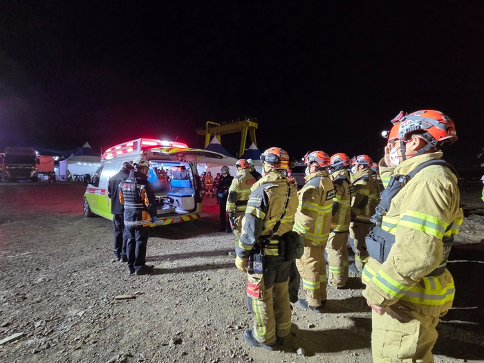 12일 오전, 울산화력발전소 붕괴 현장에서 수습된 매몰자를 병원으로 이송하기에 앞서 소방대원들이 거수경례와 묵념을 하고 있다. 사진|소방청