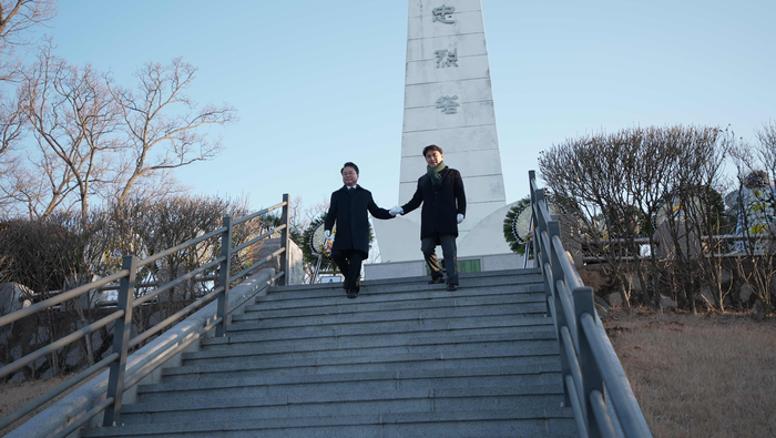 육동한 춘천시장이 2일 우두동 충렬탑에서 신년참배를 마치고 김진태 강원특별자치도지사(오른쪽)와 손을 맞잡고 계단을 내려오고 있다. 사진|춘천시청