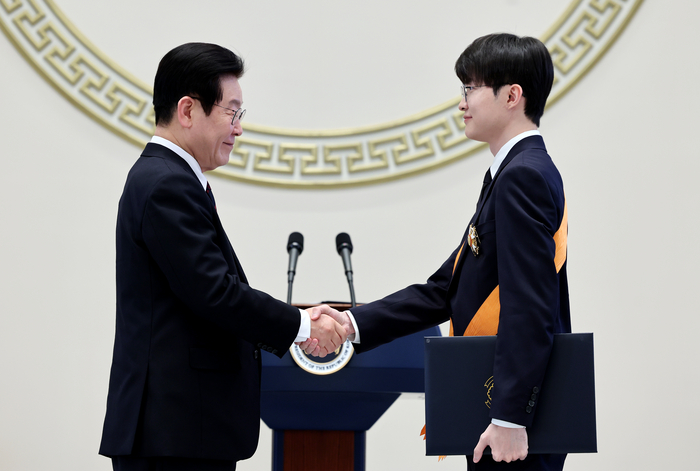 이재명 대통령이 2일 청와대 영빈관에서 열린 신년 인사회에서 프로게이머 ‘페이커’ 이상혁 선수에게 체육훈장 청룡장을 수여하고 있다. 2026.1.2 사진 | 연합뉴스 