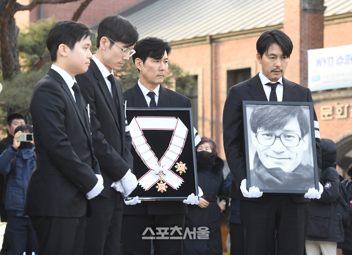 배우 이정재(오른쪽 둘째)와 정우성(맨 오른쪽)이 9일 서울 중구 명동성당에서 진행된 장례미사를 마친 뒤 금관문화훈장과 영정을 들고 대성전을 빠져나오고 있다. 왼쪽부터 故 안성기 차남 안필립, 장남 안다빈, 이정재, 저우성. 2026. 1. 9. 박진업 기자 upandup@sportsseoul.com 