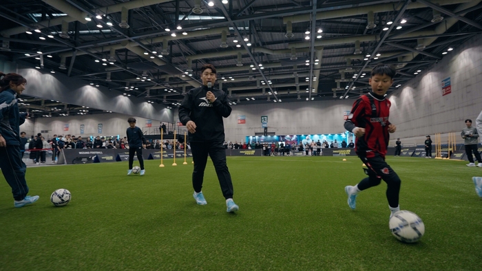축구 국가대표 공격수 출신인 이근호 해설위원(왼쪽)이 11일 일산 킨텍스에서 열린 미즈노 페스타 2026을 방문해 유소년에게 드리블 스킬을 알려주고 있다. 사진 | 한국 미즈노