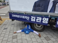 유세차량 바퀴 밑에 드러누운 선거운동원…전북지사 선거판 ‘충격’