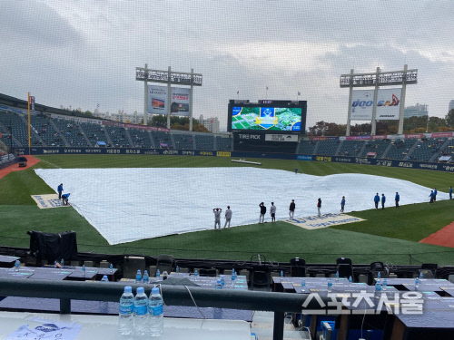 잠실구장 처음으로 대형 방수포 등장, 경기 시작 30분 지연[WC1]