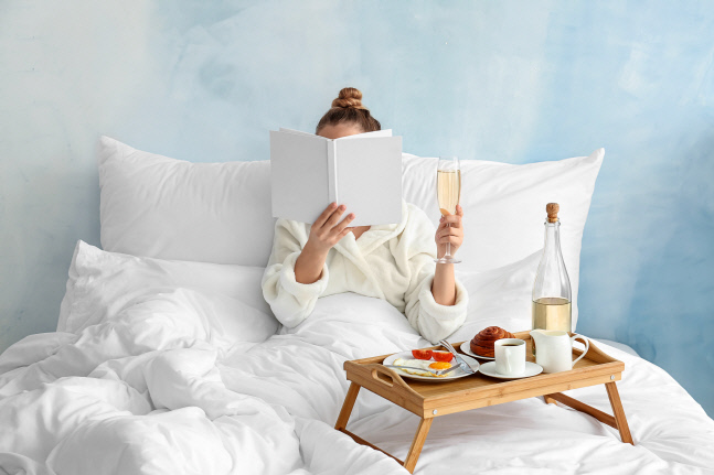 Young woman having breakfast in bed