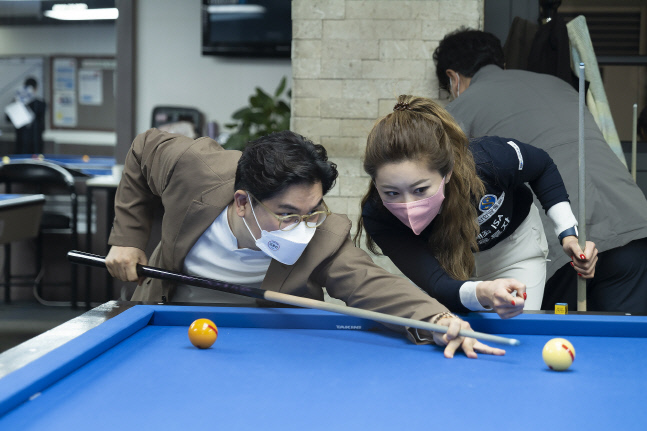 [사진 설명 5.] 김가영 선수가 방송인 김용만에게 당구 레슨을 진행하고 있다.